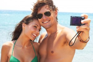 An attractive couple together at the beach, taking a selfportrait.